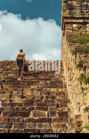 Au milieu des ruines antiques de Palenque, une femme monte des escaliers usés, sa présence témoigne de l'esprit durable de l'histoire, comme l'entrelacement passé et présent Banque D'Images