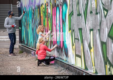 Jeunes filles peignant sur le mur du graffiti de Suvilahti à Helsinki, en Finlande Banque D'Images