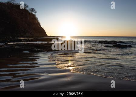 Coucher de soleil paysage photo avec ciel clair surplombant la plage de sable face à l'océan Atlantique au Nicaragua près de San Juan del sur Banque D'Images