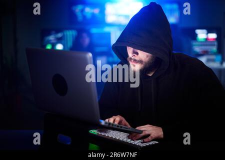 Hacker caché dans des sweatshirts et hoodie piratage des systèmes de sécurité. Concept de cyber-attaque et de programmes malveillants Banque D'Images