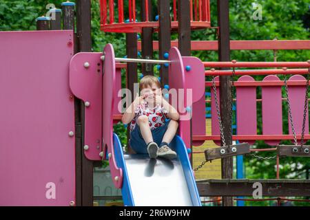 Aire de jeux moderne pour enfants dans le parc. Fabriqués dans différentes couleurs les jeunes enfants sont suspendus au bar à singes. Pour faire de l'exercice sur un terrain de jeu extérieur dans le quartier. Photo de haute qualité Banque D'Images