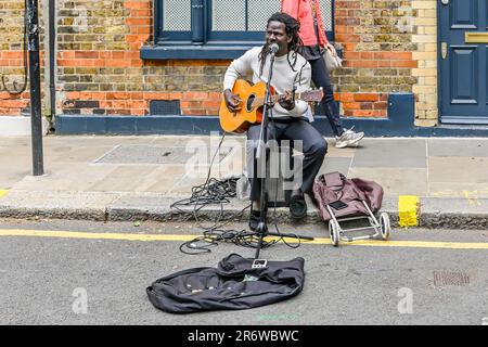 Un guitariste de l'Homme se produit au Columbia Road Flower Market, un marché de rue de l'est de Londres ouvert tous les dimanches Banque D'Images