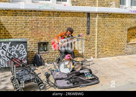 Street musicien jouant la guitare dans Brick Lane Banque D'Images