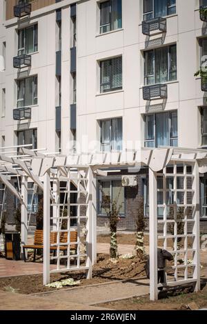 arc en bois blanc objet d'art dans la cour d'un bâtiment de plusieurs étages. Banque D'Images