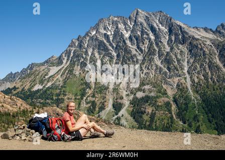 Une femme de randonnée fait une pause sur la piste. Mount Stuart, gamme Cascades, Washington Banque D'Images