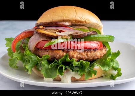 hamburger au saumon avec poivrons sautés oignons et champignons Banque D'Images