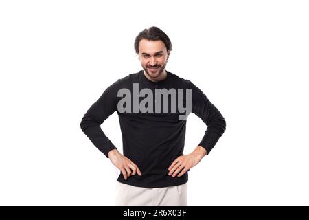 jeune homme macho européen brutal barbu avec perçage d'oreilles et cheveux noirs sur fond blanc isolé avec espace de copie Banque D'Images