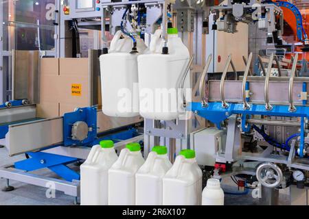 Remplissage des bouteilles avec de l'eau, factores de mise en bouteille, canisters en plastique, jerricans en plastique vides se déplaçant sur le tapis de convoyeur de la machine automatique de moulage par soufflage pour animaux de compagnie Banque D'Images