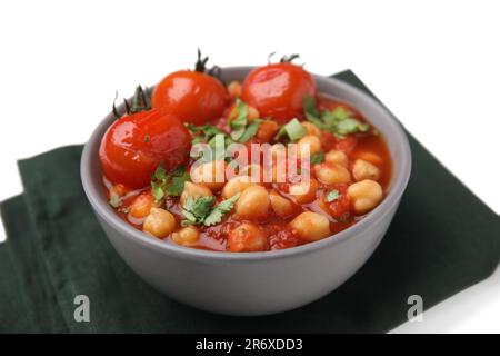 Délicieux curry de pois chiches dans un bol et tissu foncé sur fond blanc, gros plan Banque D'Images