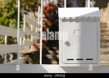 Boîte aux lettres en métal blanc sur la clôture extérieure Banque D'Images