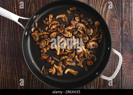 Champignons sauvages brunis dans un poêle à saute antiadhésif vue d'en haut: Vue en hauteur de l'huître, du shiitake, et des champignons crimini cuits dans le beurre Banque D'Images