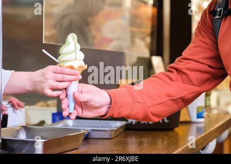 Un touriste européen achète de la glace matcha dans un kiosque à Takayama, au Japon. Banque D'Images