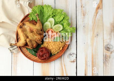 Ayam Goreng Kremes. Plat de poulet frit populaire de Jogjakarta, poulet entier friné avec garniture de chips assaisonnée Banque D'Images