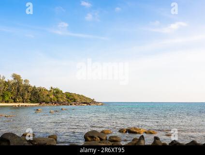 Paysage marin lumineux par temps ensoleillé. Arrière-plan d'été avec des rochers de plage, île, eau de mer claire et ciel bleu ouvert le jour du soleil, summertimes sc Banque D'Images