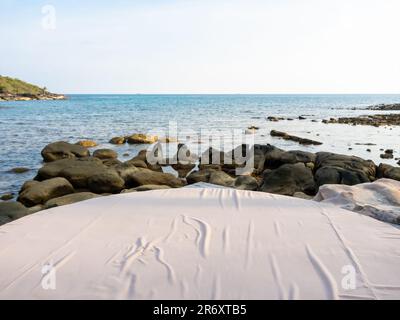 Gros plan vide Grande décoration moderne confortable coussin de lit blanc sur l'espace extérieur sur les rochers au bord de la plage en été. Lit rond circulaire avec Banque D'Images