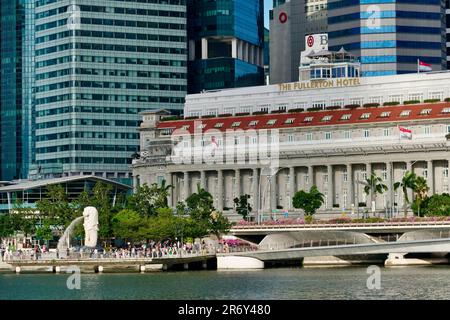 Singapour : vue sur l'hôtel Fullerton, les immeubles de bureaux du quartier des affaires et (à gauche) l'emblématique statue de Merlion dans le parc Merlion, Marina Bay Banque D'Images