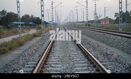 Les voies ferrées, à la campagne près de la gare, sont vues directement sur un fond flou à Jaipur Inde. Banque D'Images