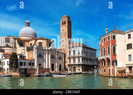 Vue sur les anciens bâtiments typiques, l'église et le beffroi sous le ciel bleu sur le Grand Canal à Venise, Italie. Banque D'Images