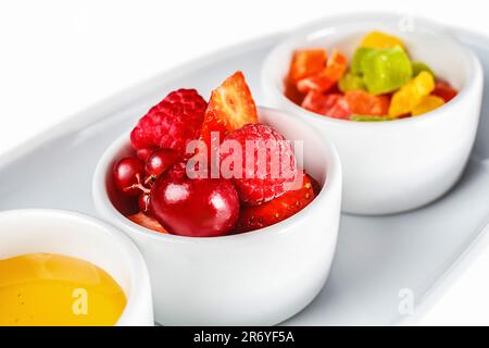 Une assiette blanche recouverte de deux bols remplis de fruits Banque D'Images