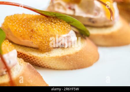 Un délicieux sandwich de petit déjeuner avec beurre, feuille de basilic frais et caviar rouge sur une baguette. Parfait pour un plat de restauration rapide. Banque D'Images