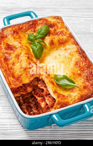 lasagnes al forno, lasagnes de bœuf italien avec du bœuf haché, sauce marinara, nouilles de pâtes et fromage ricotta dans un plat de cuisson sur table en bois blanc, Banque D'Images