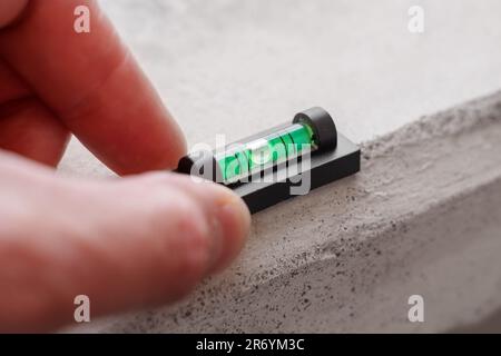 Mini-niveau à bulle sur matériau en béton Banque D'Images