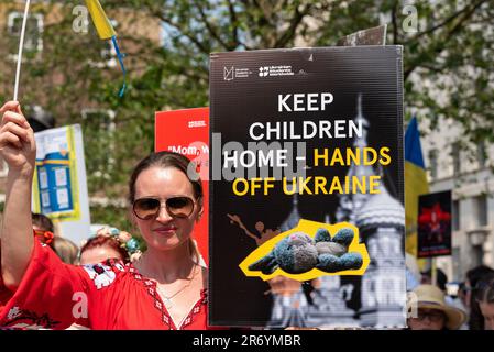 Ukraine manifestation écocide contre les actions russes pendant leur guerre contre l'Ukraine. Se déroule à Whitehall, Londres, Royaume-Uni. Affiche « Hands Off Ukraine » Banque D'Images