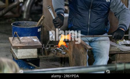 Homme formant une tige de verre dans la figurine d'animal de cheval Banque D'Images