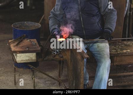 Homme artistes mains travaillant sur un morceau de verre soufflé Banque D'Images