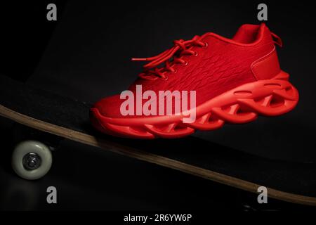 Sneaker en tissu rouge sur un plan rapproché de skateboard. Banque D'Images