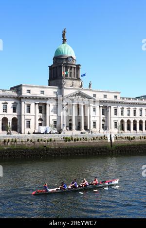 Quatre bateaux à rames en boîte passent par Customs House, sur les rives de la rivière Liffey, Dublin, Irlande Banque D'Images