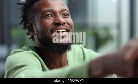 Portrait de la tête et des épaules d'un homme afro-américain contemporain souriant à l'appareil photo Banque D'Images
