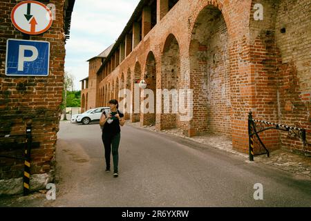 Kolomna, Russie - 30 mai 2023 : une femme marche le long de la route à l'intérieur d'un ancien château. Tourisme à l'intérieur d'une ancienne forteresse Banque D'Images