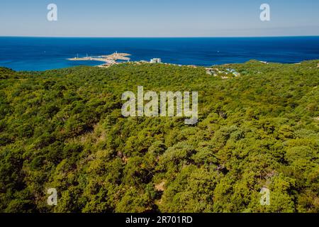 Vue aérienne du littoral avec village et forêt méditerranéenne. Banque D'Images