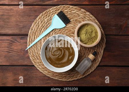 Composition avec poudre de henné et crème sur table en bois, vue du dessus. Coloration naturelle des cheveux Banque D'Images