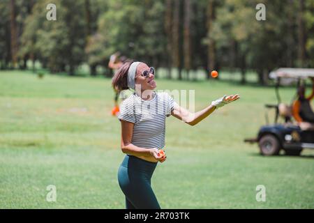 Femme jonglant avec des balles de golf au parcours de golf de Bedugul, Bali, Indonésie Banque D'Images