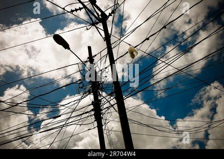 Les lignes électriques enchevêtrées dans un bidonville de Caracas, au Venezuela, représentent les crises énergétiques qui ont provoqué des pannes de courant dans tout le pays. Banque D'Images
