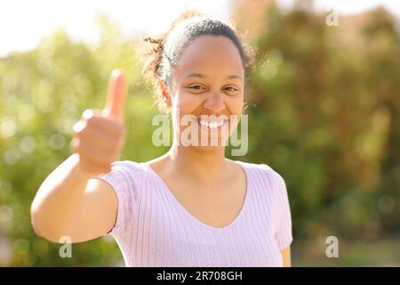 Vue de face portrait d'une femme noire heureuse qui fait des gestes à l'extérieur Banque D'Images