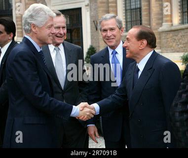 Le président américain George W. Bush, de droite, et son père, l'ancien américain Président George H.W. Bush, de gauche, se présente comme le Premier ministre italien Silvio Berlusconi, de droite, et les anciens États-Unis Le président Bill Clinton, à gauche, serrer la main jeudi, 7 avril 2005, Avant le dîner à la résidence du Premier ministre à Rome. La visite a eu lieu la veille des funérailles de vendredi du Pape Jean-Paul II Crédit obligatoire : Eric Draper/Maison Blanche via CNP Banque D'Images