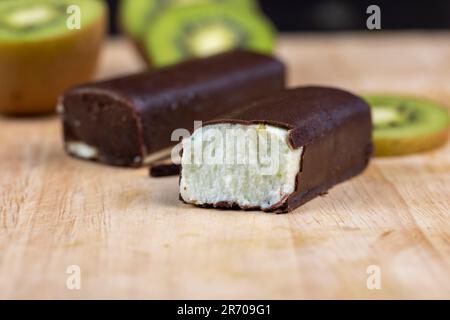 fromage cottage vert doux avec saveur de kiwi dans un glaçage au chocolat, délicieux dessert fromage cottage au chocolat Banque D'Images