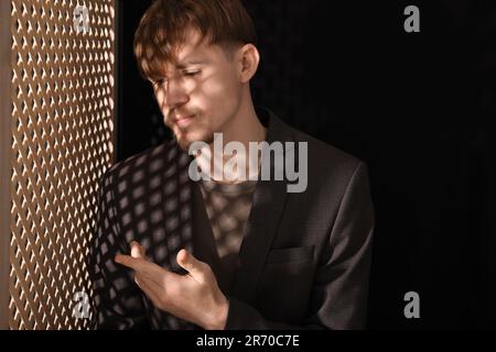 Bouleverser le jeune homme lors de la confession dans le stand Banque D'Images