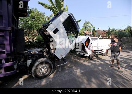 10 juin 2023, Kulonprogo, Yogyakarta, Indonésie: Un mini camion passe devant un vrai camion dans un village résident de Kulonprogo, Yogyakarta, le 12 juin 2023. Le chariot utilise un moteur de moto modifié. Le camion à jouets a une conception qui ressemble à un camion en général, mais a des dimensions beaucoup plus petites avec des fonctions avant, arrière et de levage derrière le lit. Un jeune homme nommé Imam, le propriétaire de Rimbono garage, a déclaré que le but de fabriquer le mini-camion était initialement seulement de répondre aux demandes des fans sur les médias sociaux. parce qu'avant de fabriquer des voitures jouets, le corps du camion était purement fait à la main f Banque D'Images