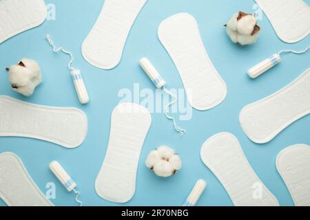 Tampons et tampons menstruels sur fond bleu. Cycle menstruel. Hygiène et protection. Vue de dessus. Banque D'Images