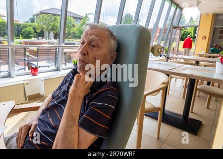 pensionné de la vieillesse assis à la table dans la maison de repos Banque D'Images