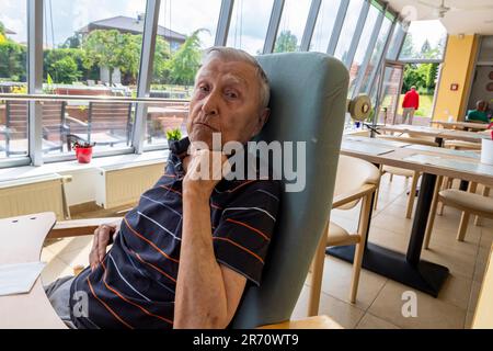 pensionné de la vieillesse assis à la table dans la maison de repos Banque D'Images