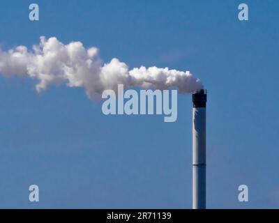 De la vapeur s'échappe dans l'atmosphère d'une cheminée de l'usine Greenatham Works de Venator Chemical. Vu contre un ciel bleu Banque D'Images