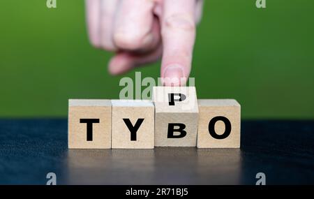 Symbole pour corriger une faute de frappe. La main tourne les dés et corrige l'expression tybo à typo. Banque D'Images
