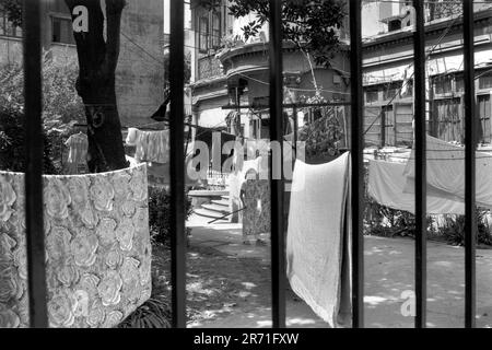 Logement public, Shanghai Chine Femme traînant des vêtements de famille laver pour sécher sur la corde à linge dans le jardin de la cour de l'ancienne villa privée, 2000. HOMER SYKES des années 2000 Banque D'Images