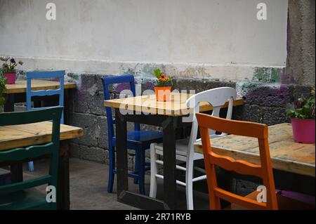 Tables et chaises de bistro colorées dans un patio resto local sur la via Pardo à Catane Sicile, Italie. Banque D'Images