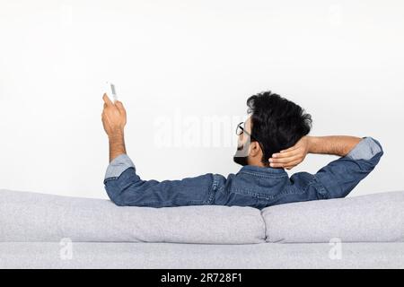 Gros plan sur la vue arrière d'un homme barbu tenant la télécommande Banque D'Images